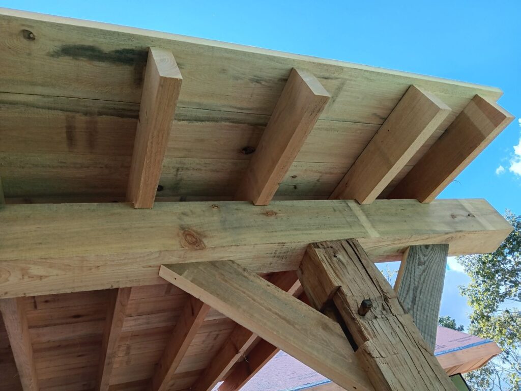 Wood beam structure against blue sky.