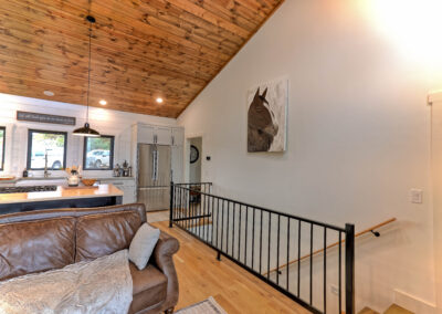 Cozy living room with kitchen and horse painting.