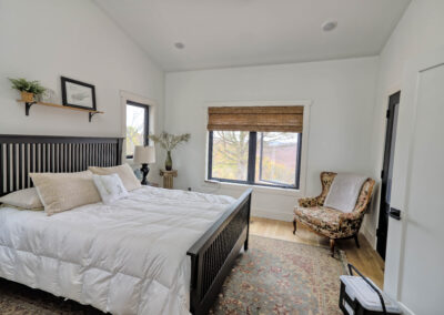 Cozy bedroom with large window and armchair.