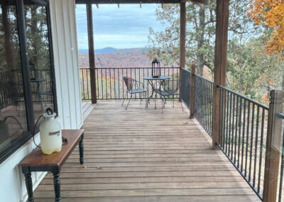 Wooden deck with mountain view and seating area.