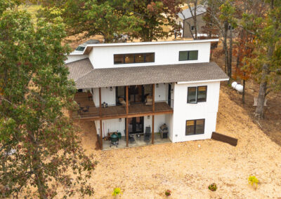 Modern two-story house surrounded by trees.