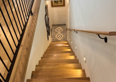 Wooden staircase with decorative railing and artwork