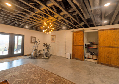 Basement gym with wooden sliding doors and bunk bed.