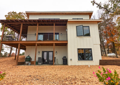 Modern two-story house with balcony and fall foliage.