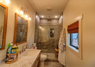 Modern bathroom with glass shower and marble countertop.