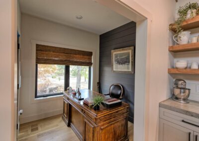 Home office with wooden desk and window view.